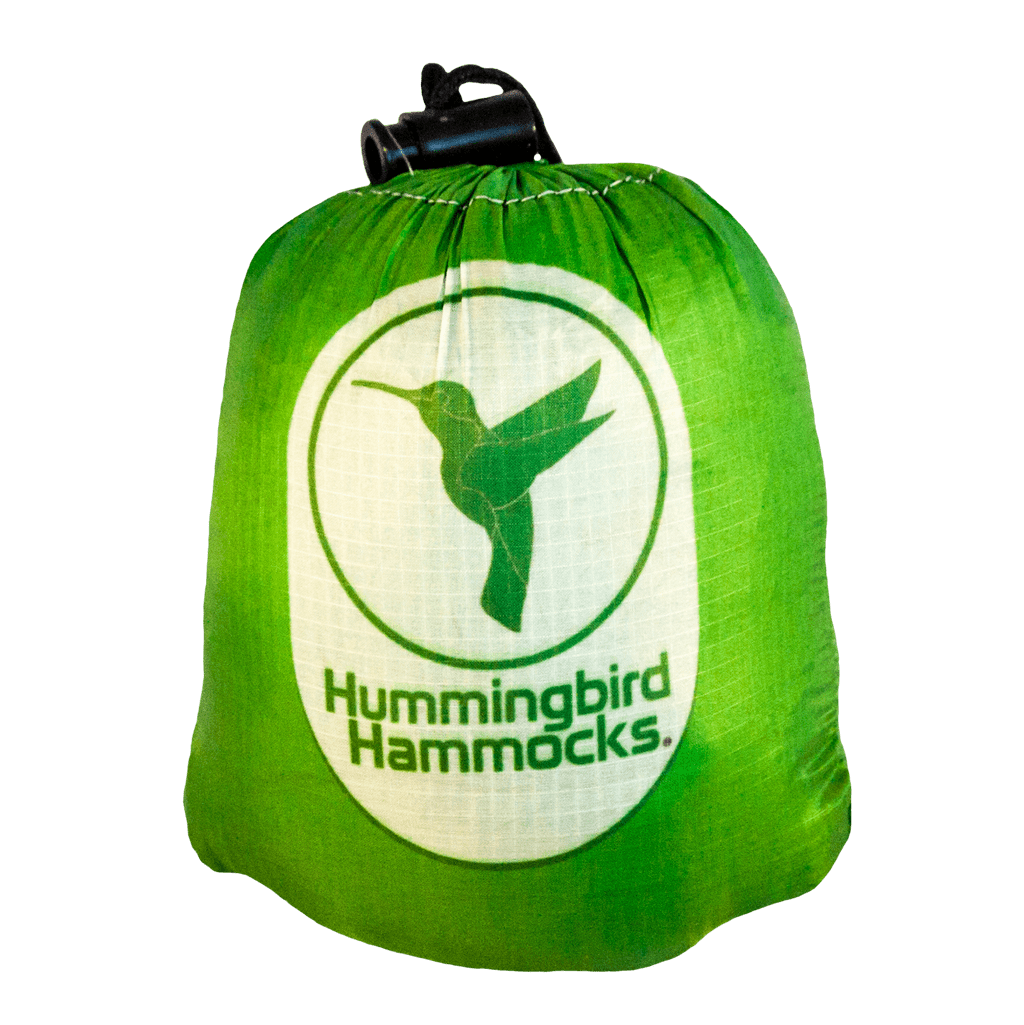 Green storage bag featuring a white logo of a hummingbird and the text "Hummingbird Hammocks Ultralight Single+ Hammock.