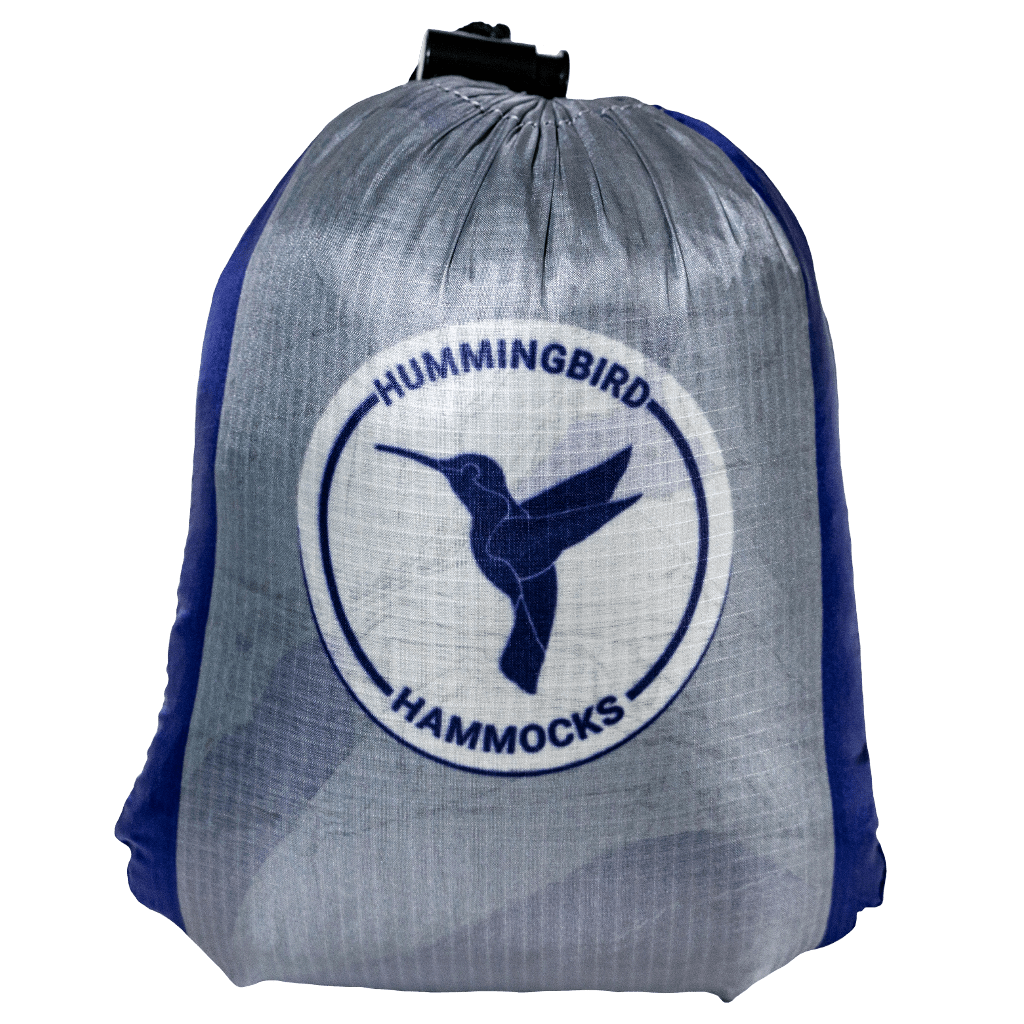 A gray stuff sack featuring the Hummingbird Hammocks logo with a blue hummingbird silhouette on a white circular background and equipped with a Button Link attachment system for the Double Hammock.