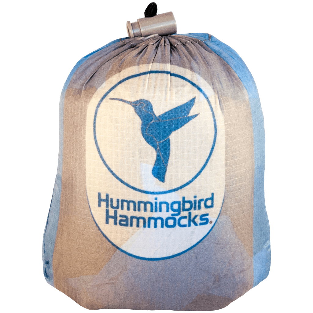 A Hummingbird Hammocks branded ultralight Double Hammock with a logo featuring a hummingbird in flight, against a circular blue and white background.