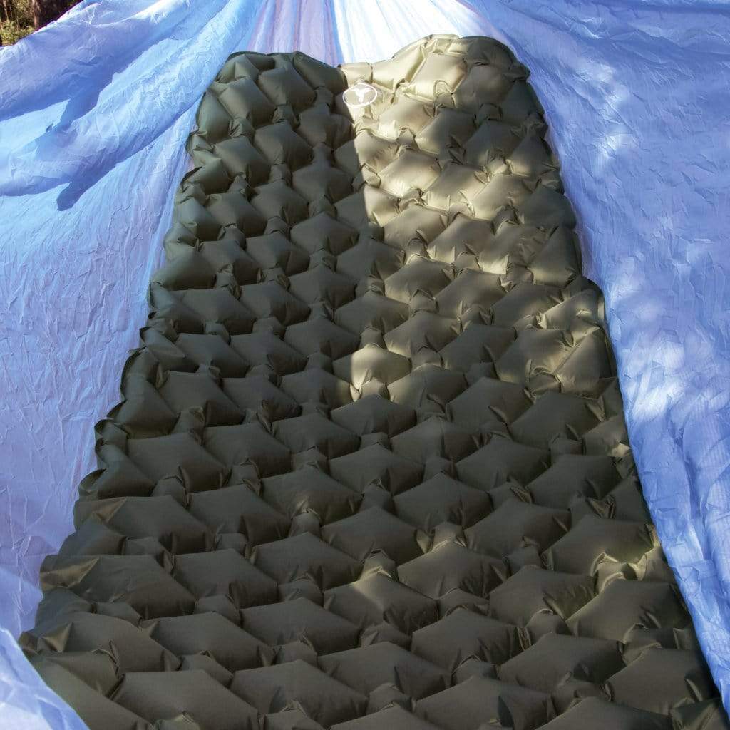 An inflatable Junco Sleeping Pad with a high R-Value placed inside a blue camping tent by Hummingbird Hammocks.