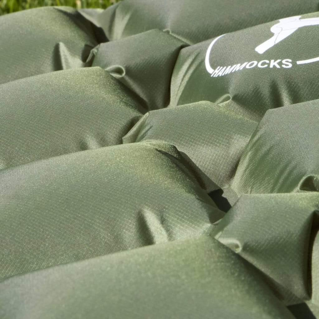 Close-up of a green woven fabric with a logo reading "Hummingbird Hammocks" partially visible, indicating the material is likely part of a hammock.