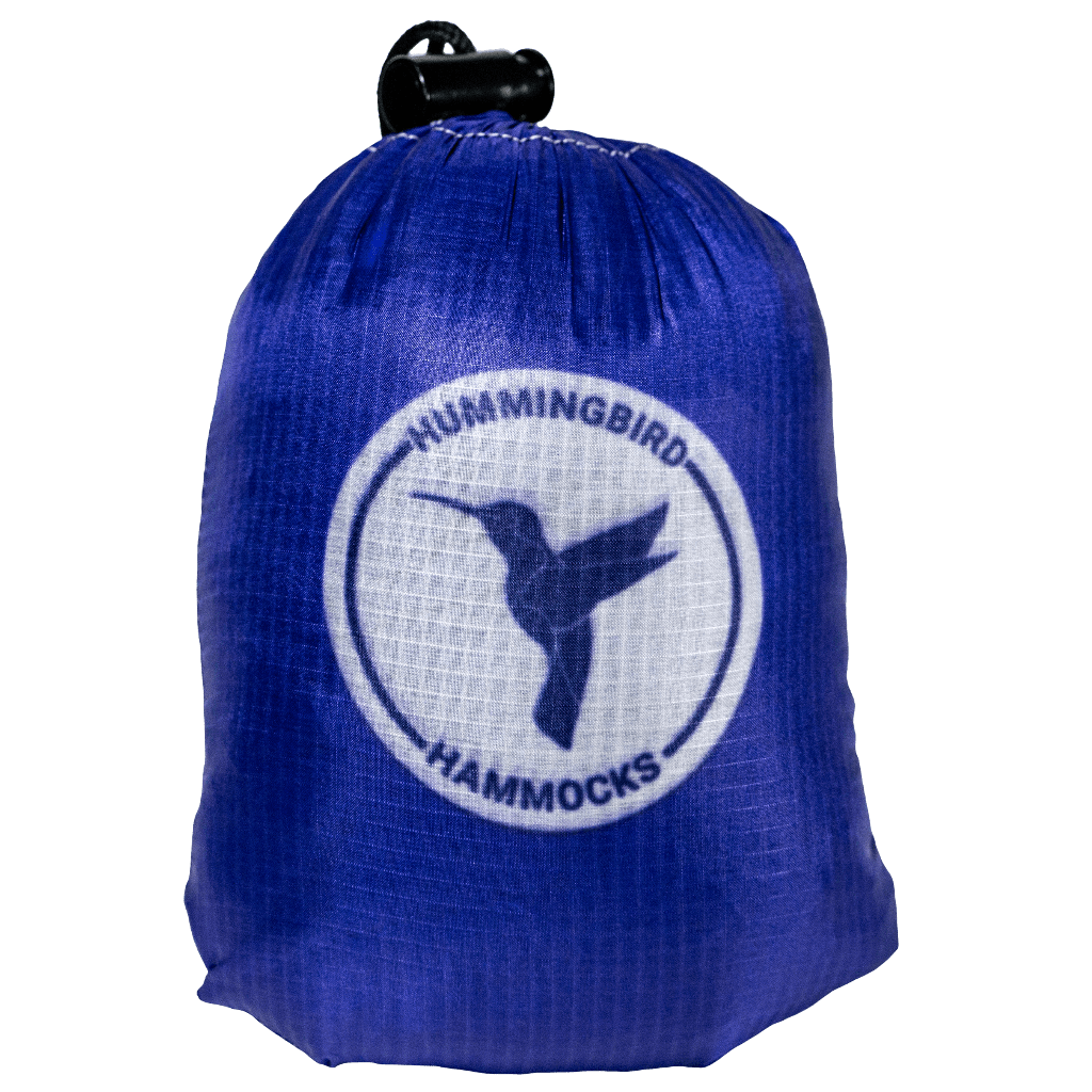 Blue drawstring bag with a white logo featuring a hummingbird and the text "Single+ Hammock" by Hummingbird Hammocks, incorporating parachute technology.