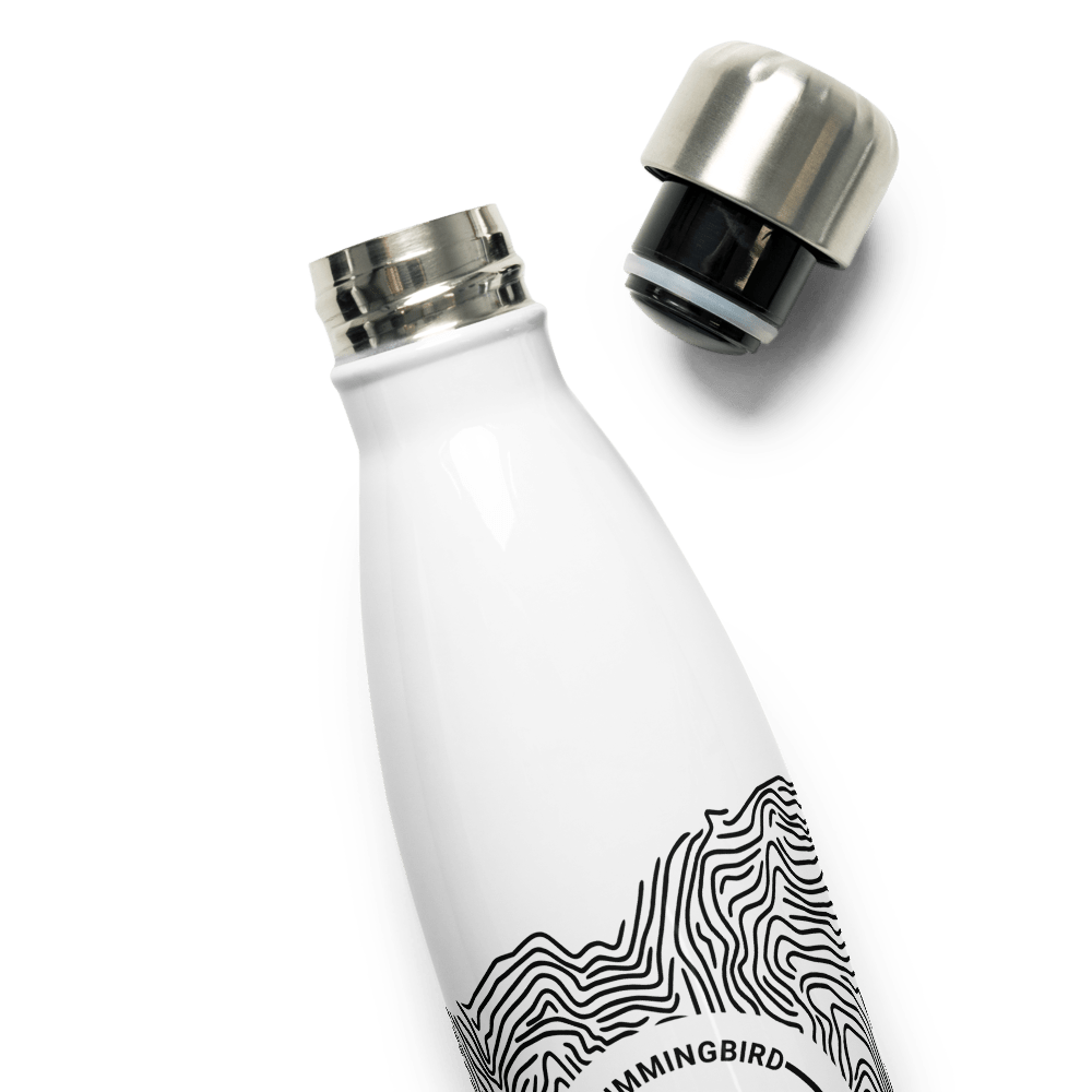A white reusable double-walled Topographic Stainless Steel Water Bottle with a black and white abstract design, featuring an open stainless steel lid, against a green background by Hummingbird Hammocks.