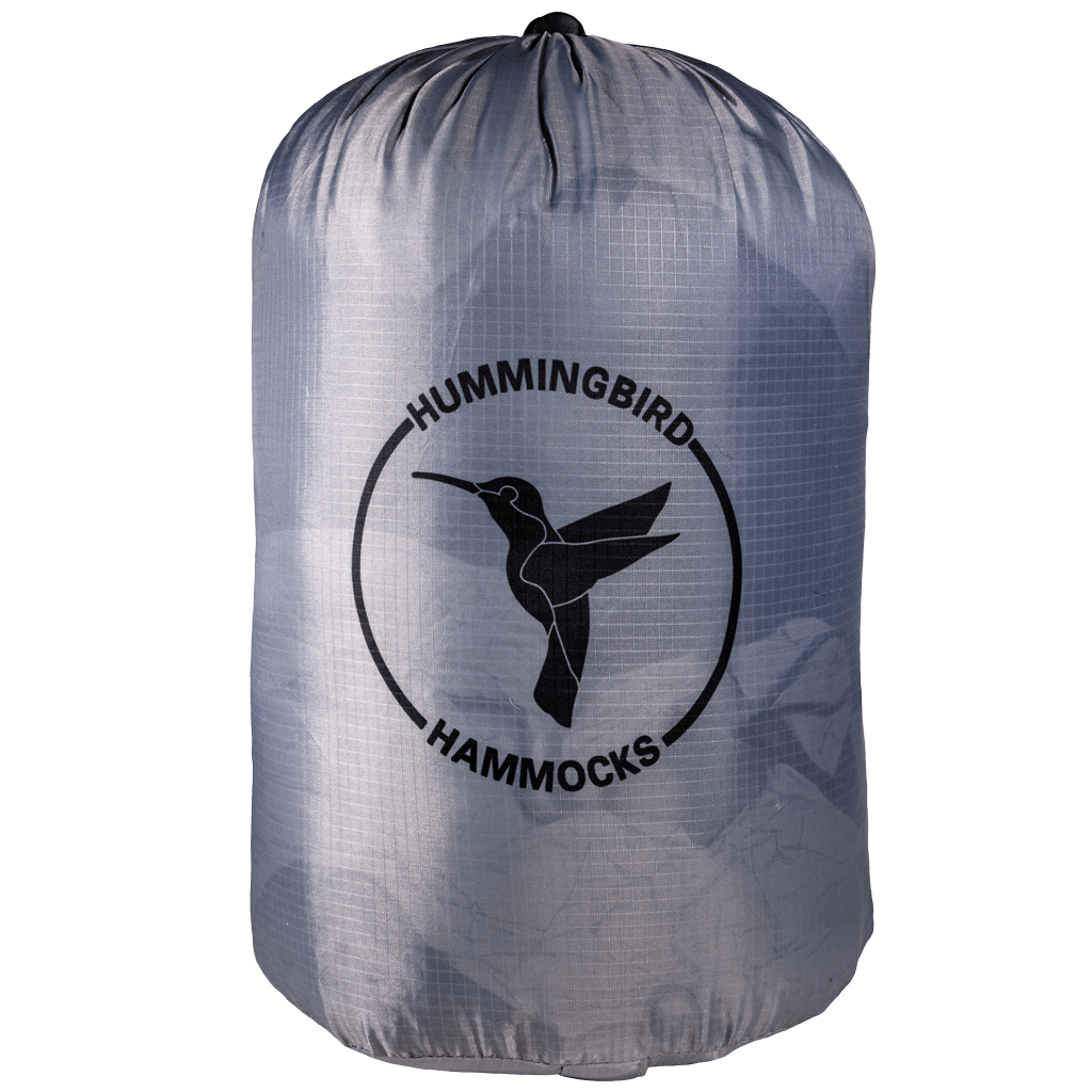 A gray Puffin Underquilt storage bag with the "Hummingbird Hammocks" logo featuring a silhouette of a hummingbird in flight.